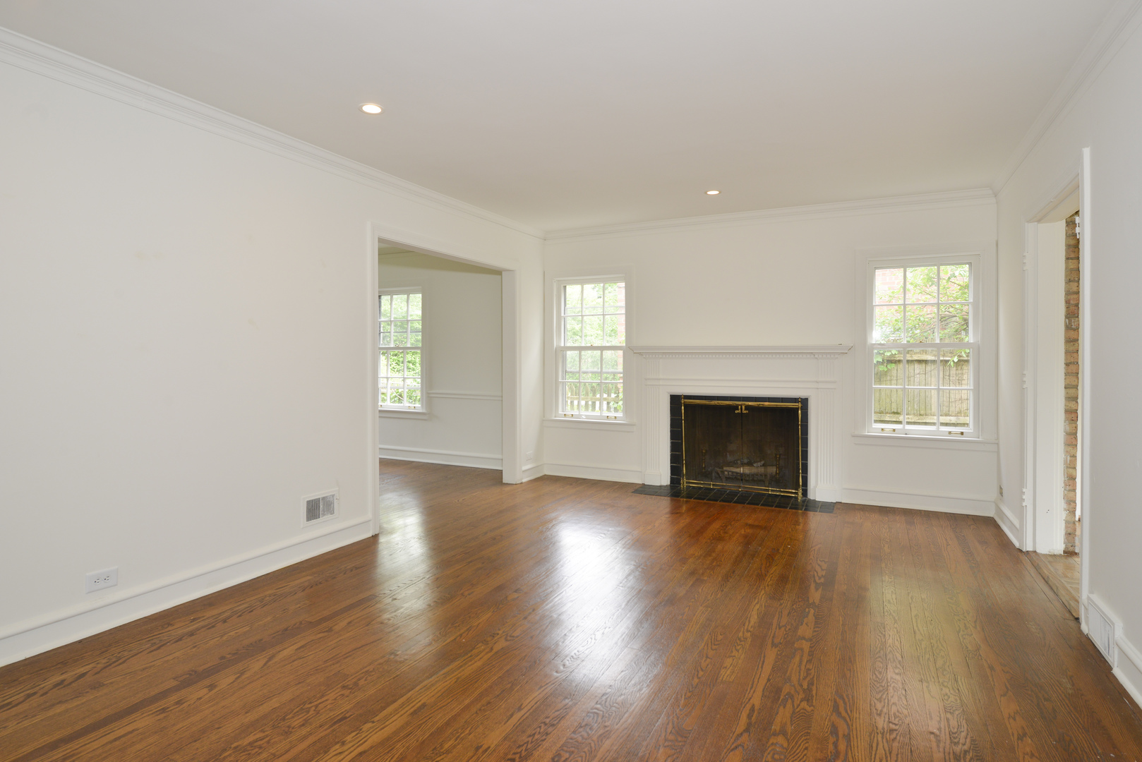 82 Warwick Road Winnetka, IL 60093 - Photo 3 of 24 an empty room with wooden floor fireplace and windows