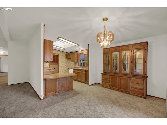 a view of a livingroom with furniture cabinet wooden floor and a chandelier