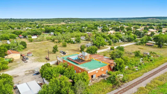 an aerial view of residential houses with outdoor space and trees