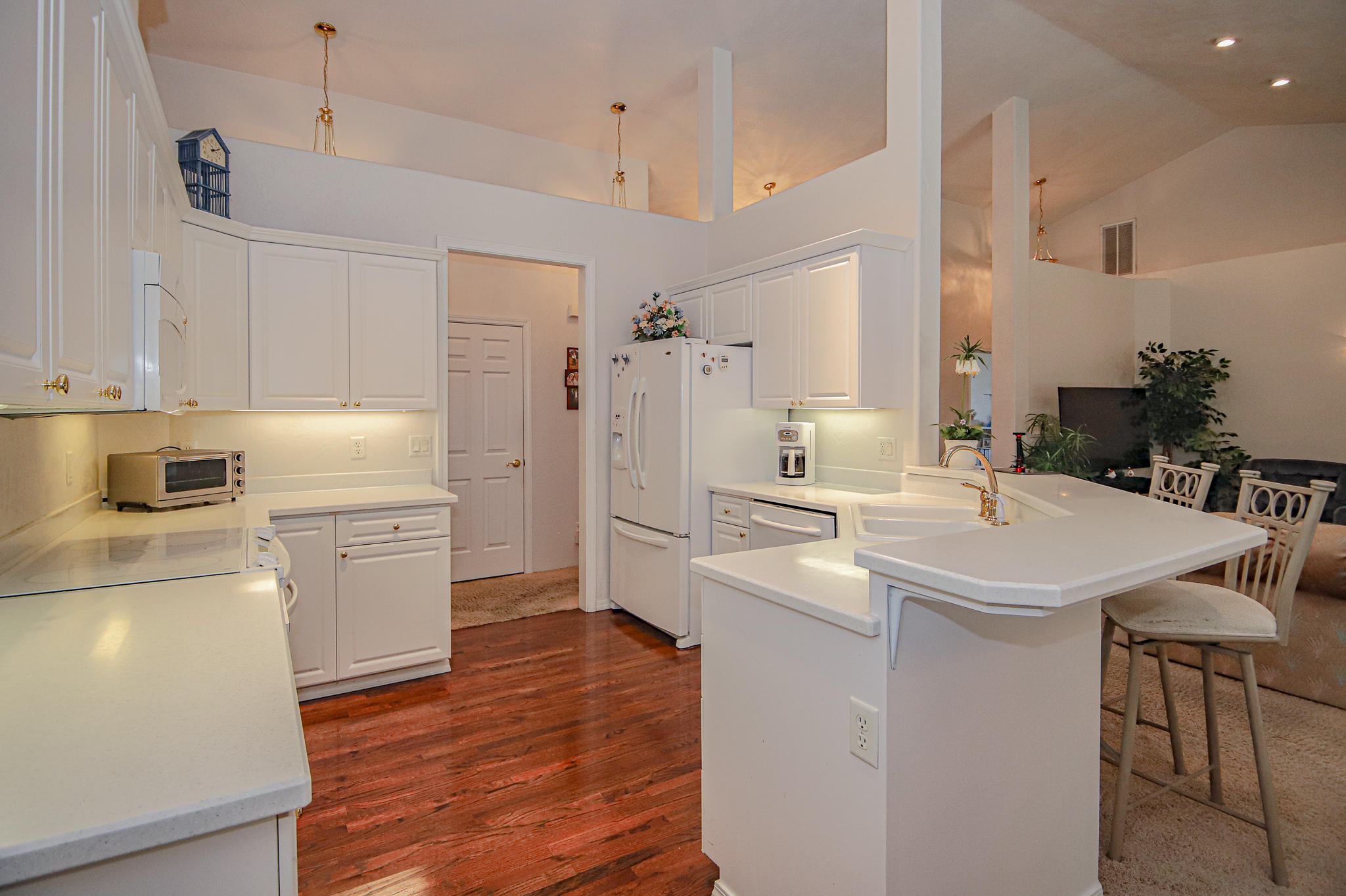 2876 Beebe Road Central Point, OR 97502 - Photo 14 of 34 a kitchen with a sink a stove a refrigerator and white cabinets with wooden floor