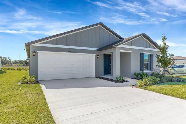 a front view of house with yard and garage