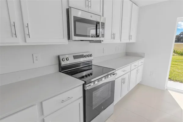 a kitchen with white cabinets and appliances