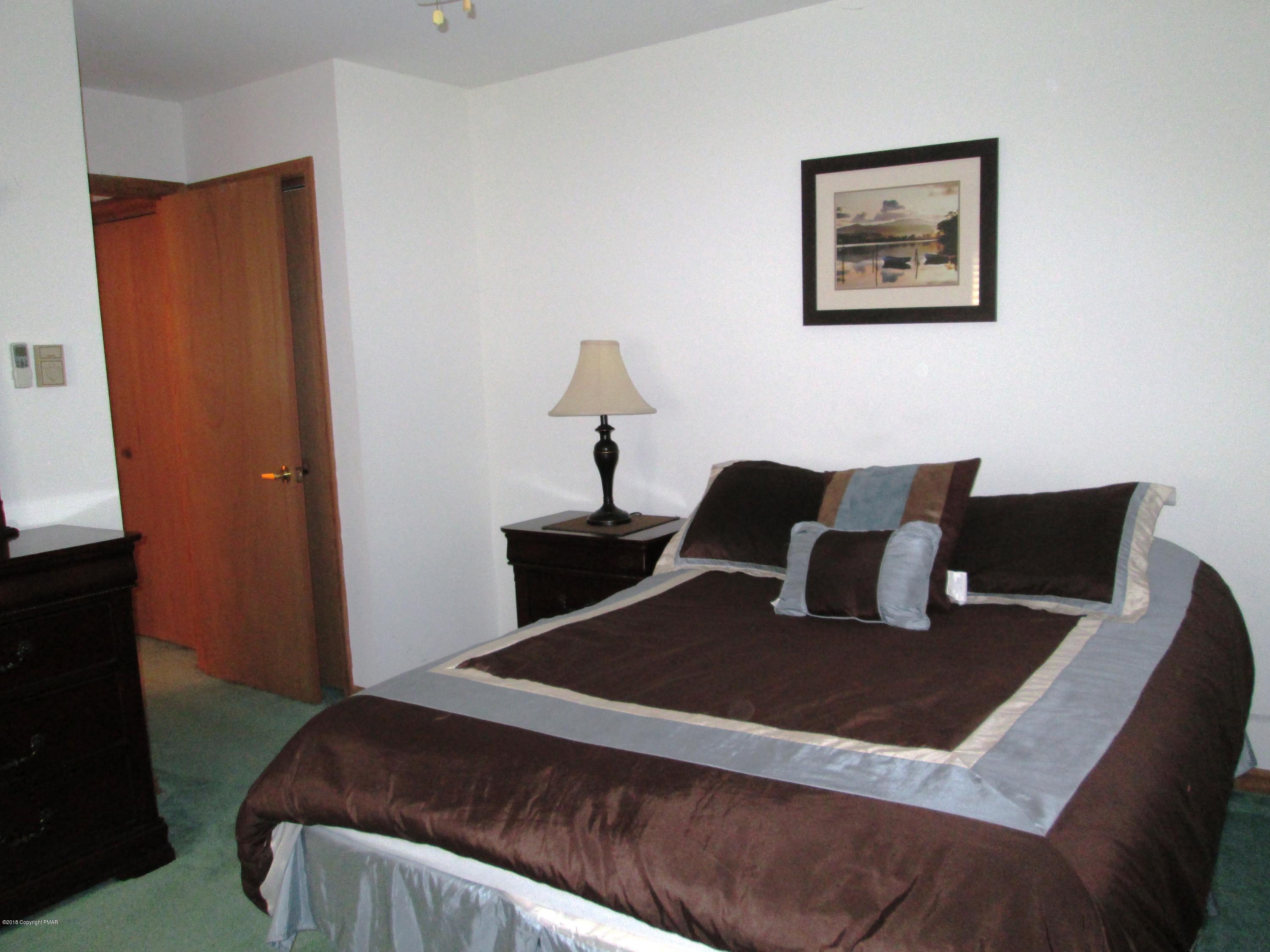 118 Lidio Road Blakeslee, PA 18610 - Photo 7 of 19 a bedroom with a bed and a lamp on dresser