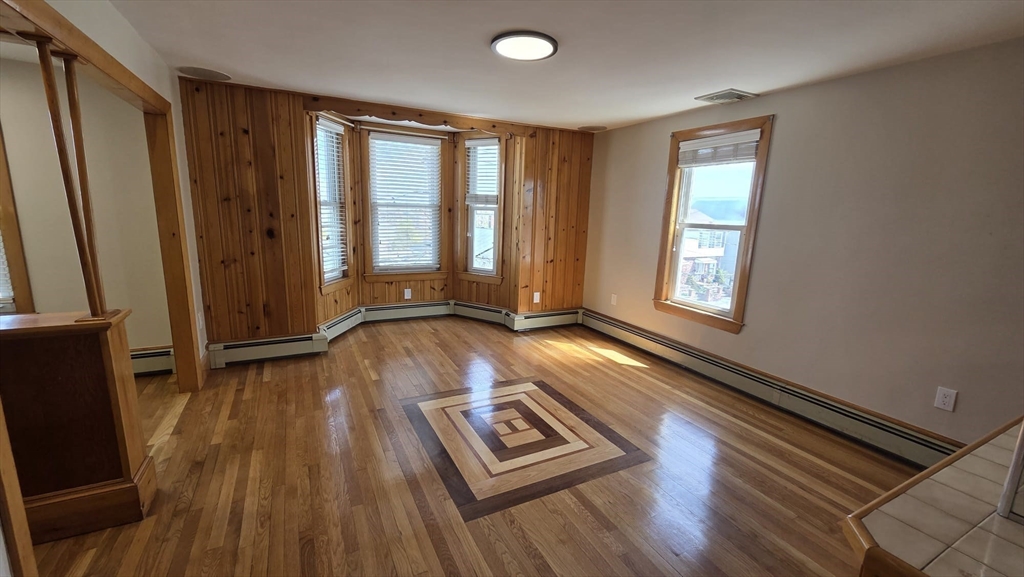 63 Carroll Street, Unit 2 Chelsea, MA 02150 - Photo 3 of 19 a view of an empty room with wooden floor and a window