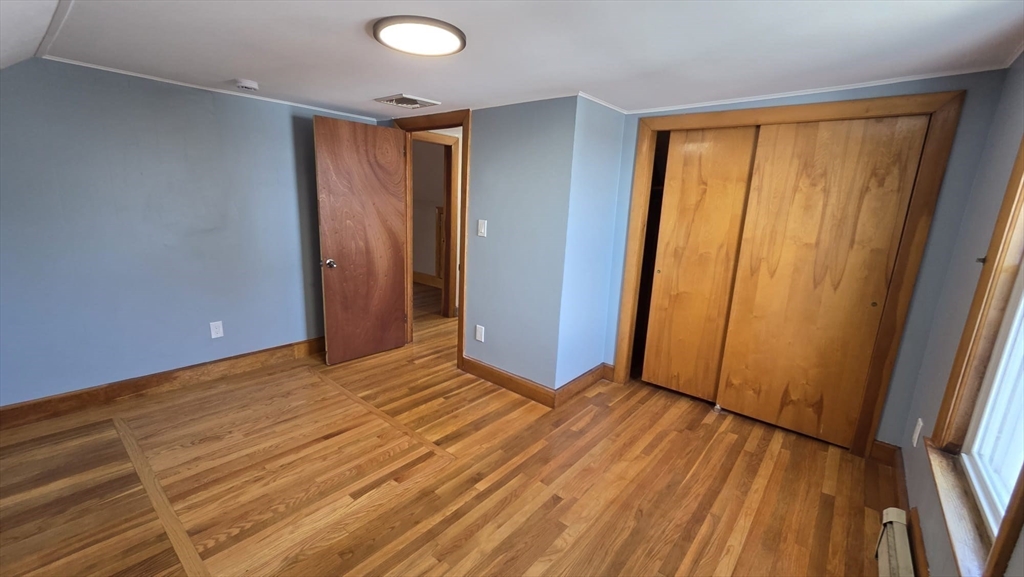 63 Carroll Street, Unit 2 Chelsea, MA 02150 - Photo 7 of 19 a view of an empty room with wooden floor and a window