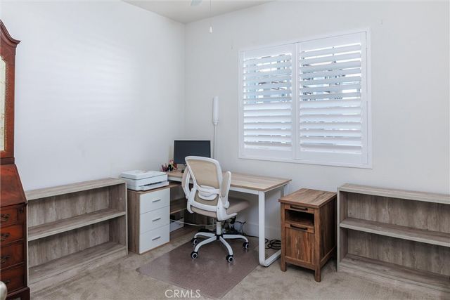 a view of a workspace with furniture and a window