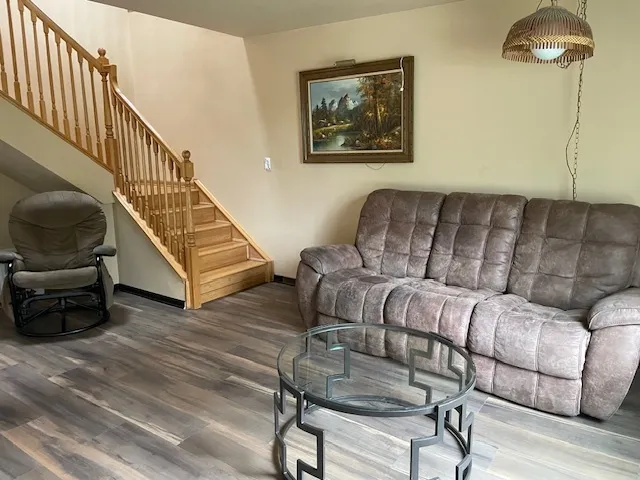 a living room with furniture and a wooden floor