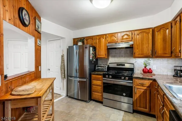 a kitchen with stainless steel appliances granite countertop a refrigerator stove and sink
