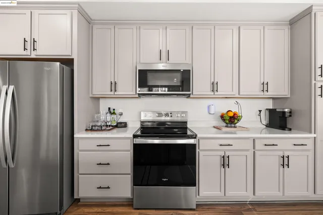 a kitchen with white cabinets and stainless steel appliances