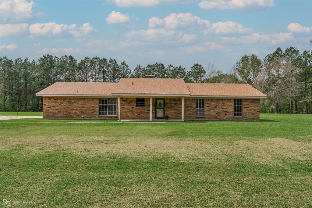 Ranch-style house with brick siding, a front lawn, and a porch