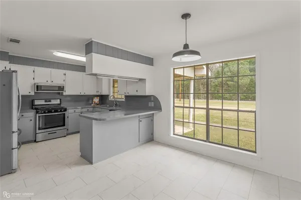 a kitchen with stainless steel appliances granite countertop a stove a sink and a refrigerator