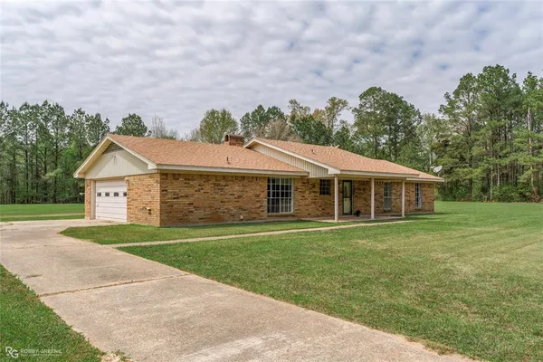 a front view of a house with a yard and trees