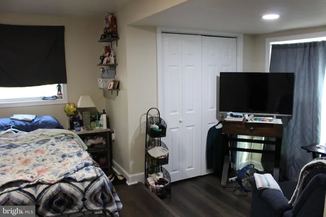 a bedroom with a bed and flat tv screen on the dresser
