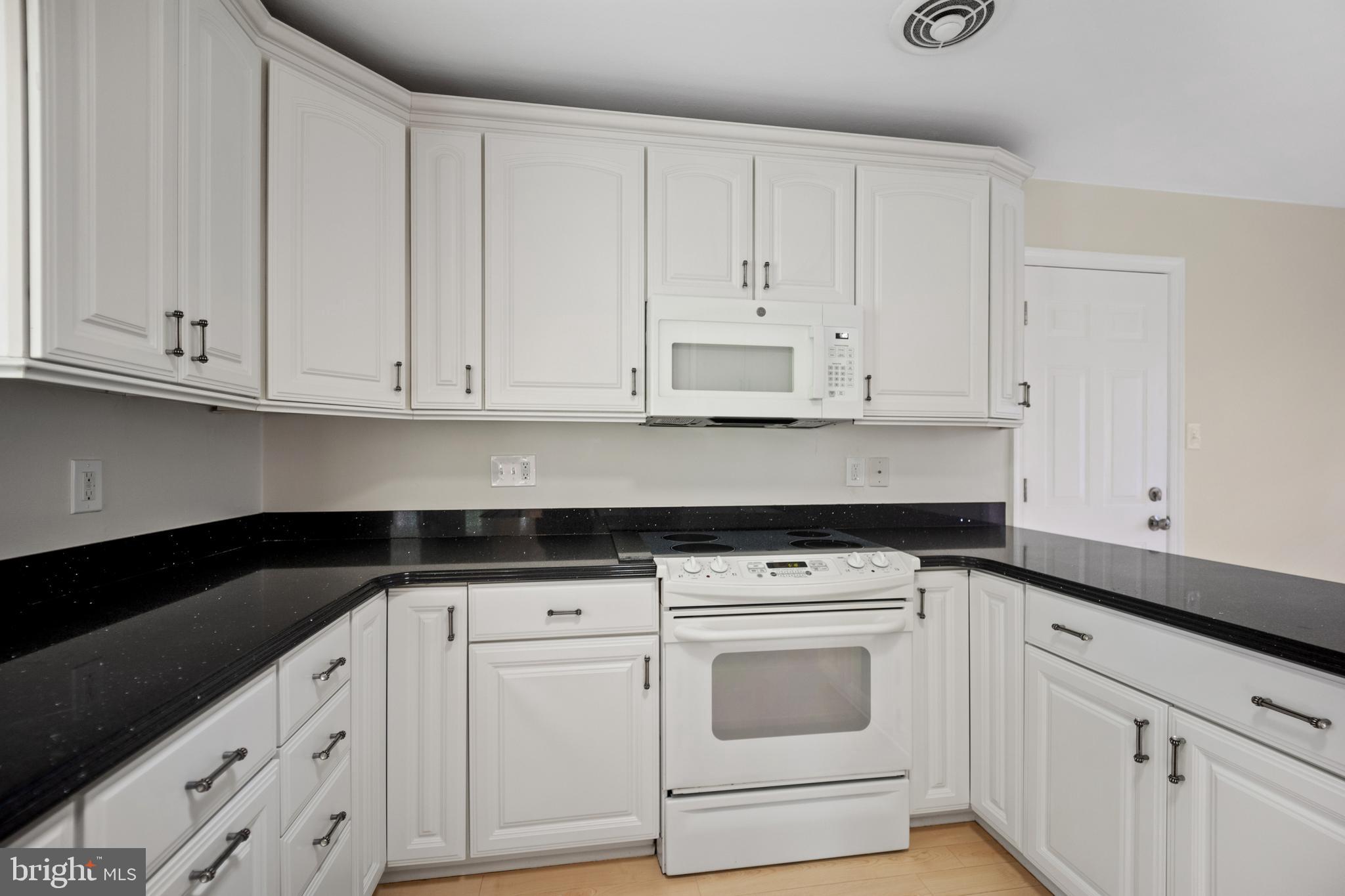 705 Halstead Road Wilmington, DE 19803 - Photo 11 of 34 a kitchen with granite countertop white cabinets and white appliances
