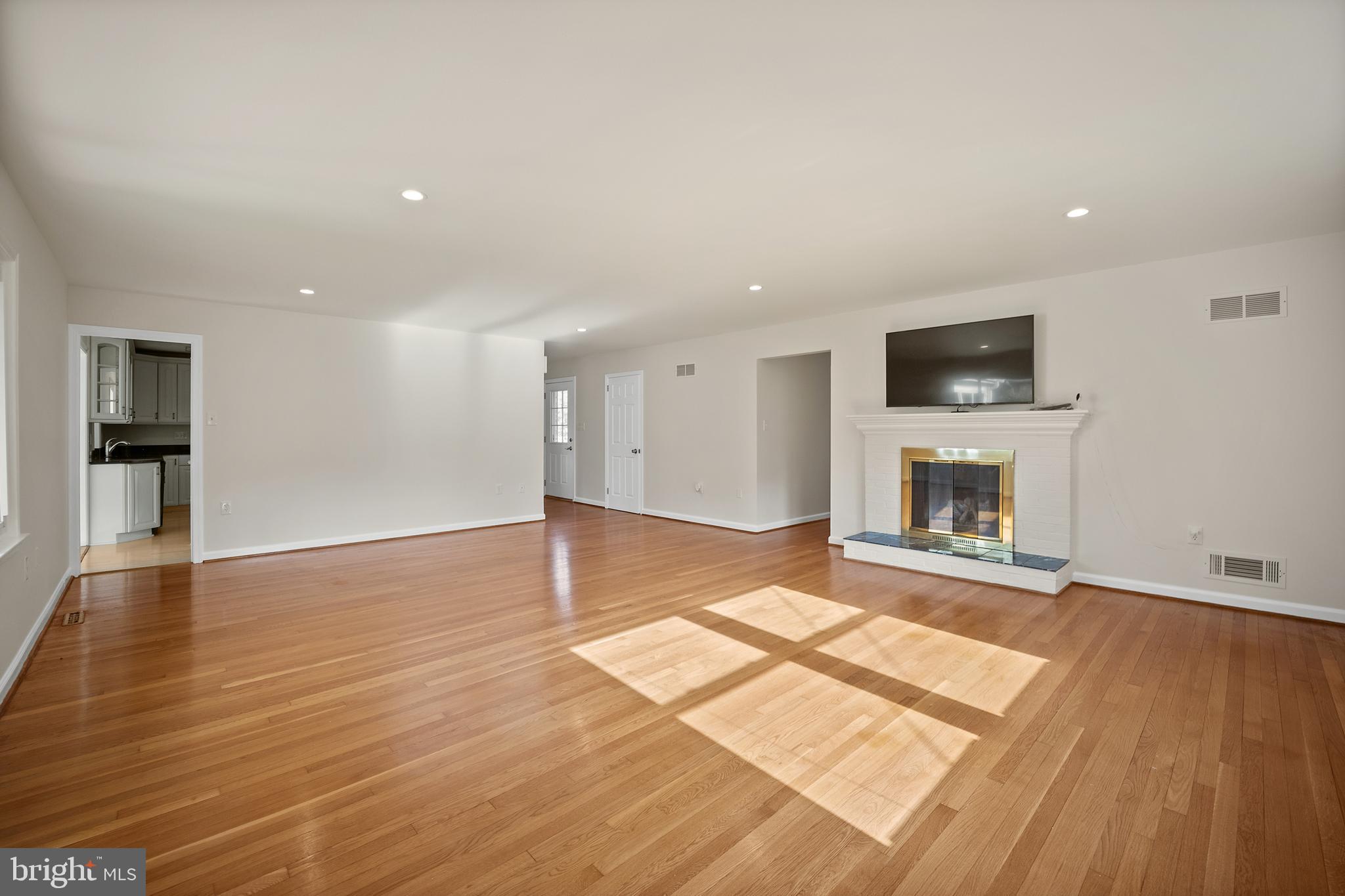 705 Halstead Road Wilmington, DE 19803 - Photo 6 of 34 an empty room with wooden floor and fireplace