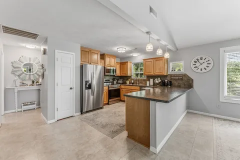 a kitchen with stainless steel appliances granite countertop a refrigerator and a stove top oven
