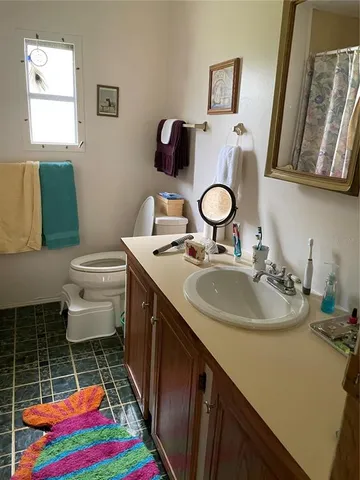 a bathroom with a sink vanity mirror and toilet