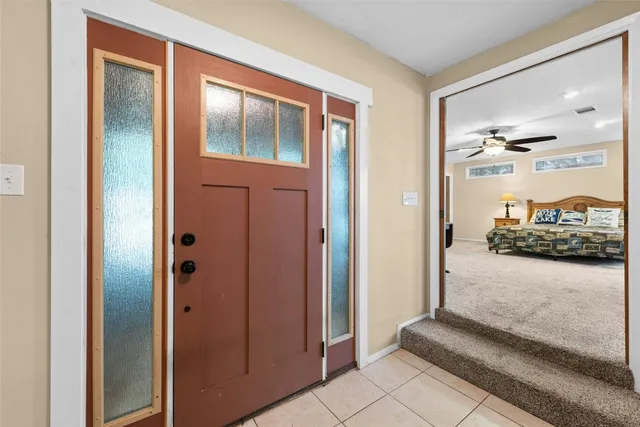 a view of a hallway with bathroom and glass door