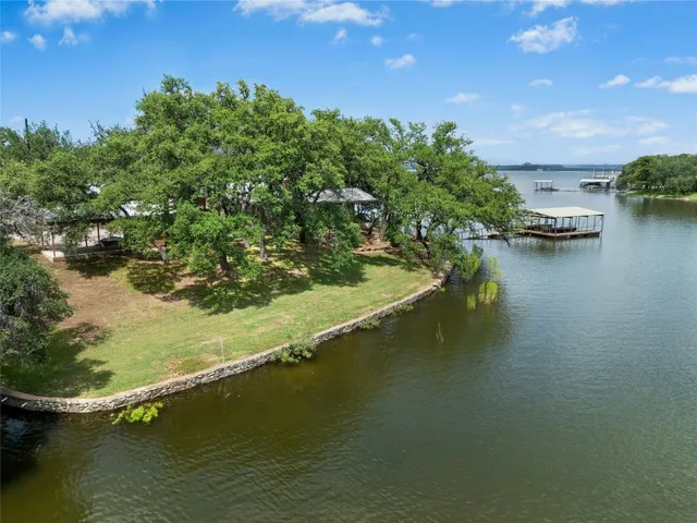 an aerial view of water body with boats and trees all around