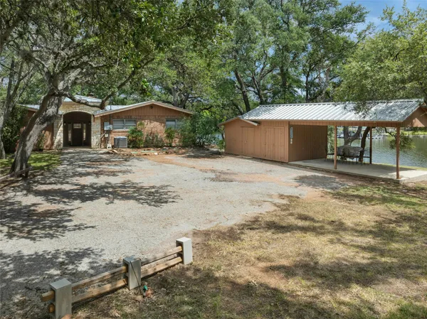 a view of a house with a yard and large tree