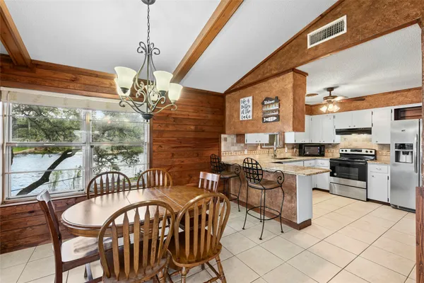 a dining room with furniture a chandelier and window