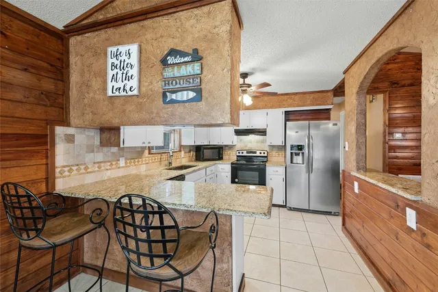 a kitchen with stainless steel appliances kitchen island granite countertop a refrigerator and a stove