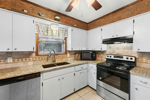 a kitchen with a sink stove and microwave