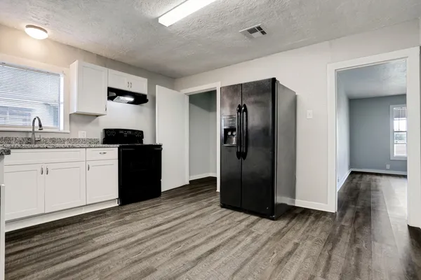 a kitchen with stainless steel appliances granite countertop a refrigerator and a sink