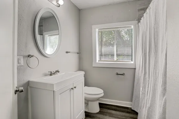 a bathroom with a toilet a sink and a mirror