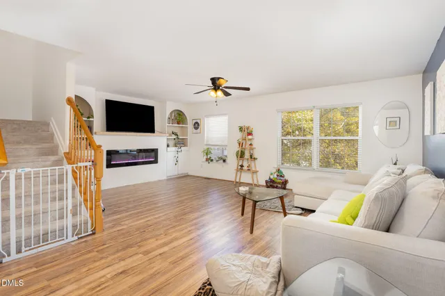 a view of empty room with wooden floor and fan