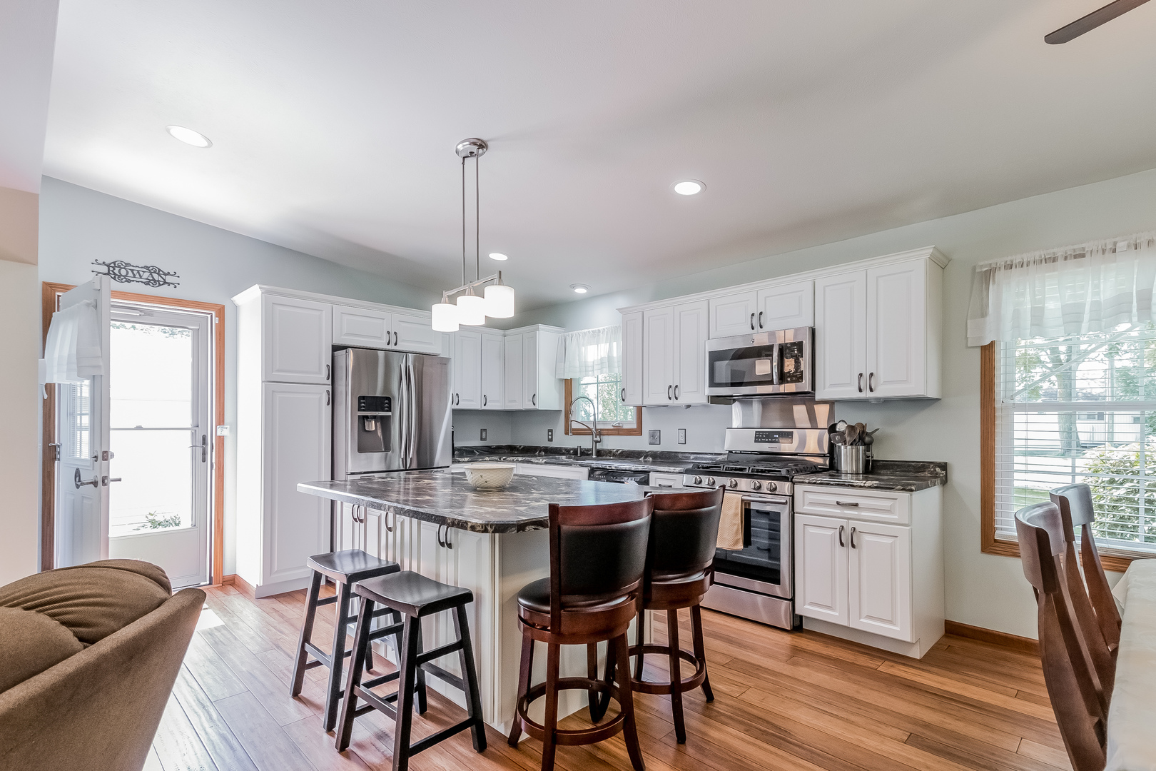 7911 South Sugar Island Road Chebanse, IL 60922 - Photo 6 of 16 a kitchen with stainless steel appliances kitchen island granite countertop a sink a stove a dining table and chairs