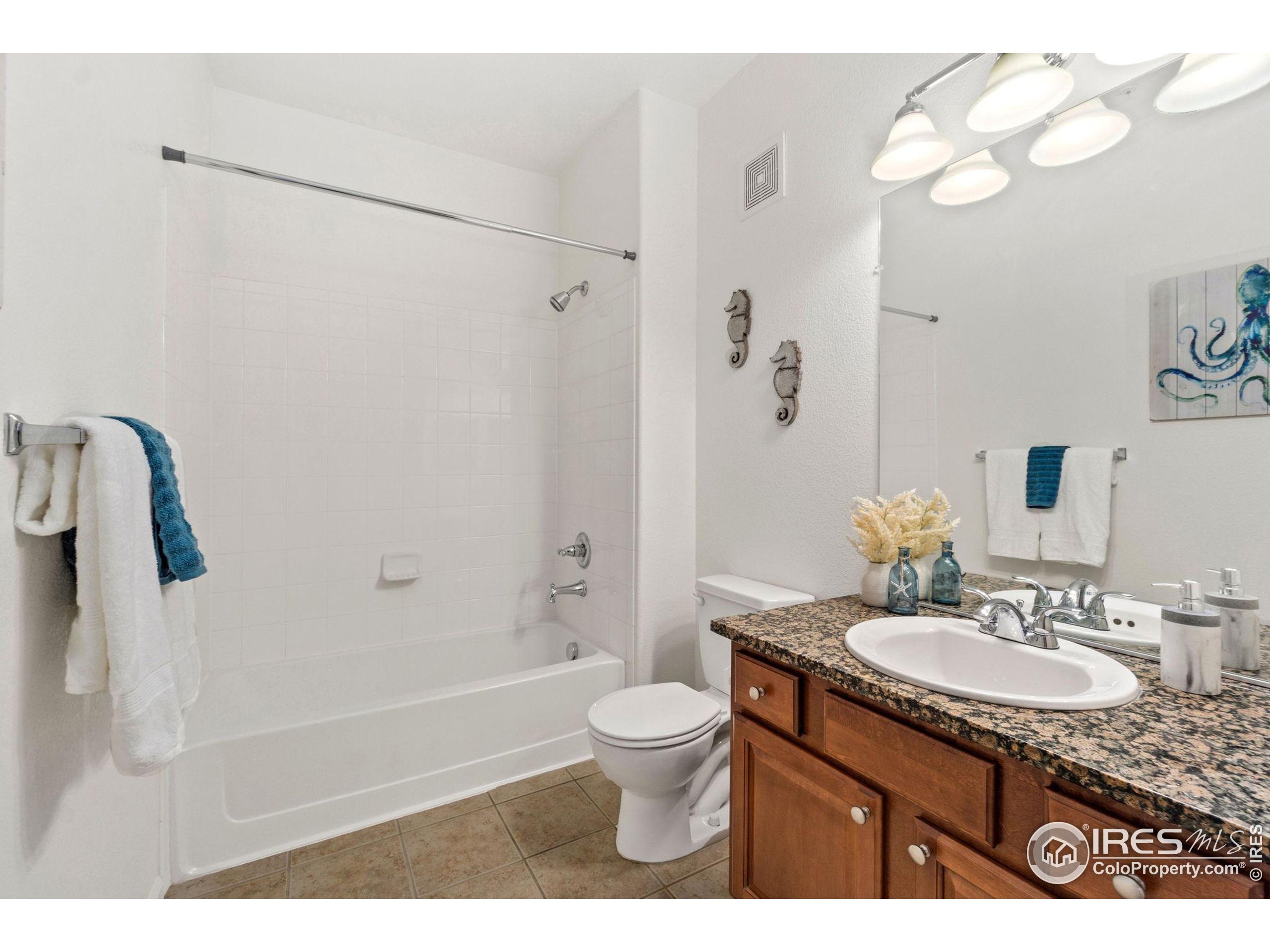 Undisclosed Address Erie, CO 80516 - Photo 11 of 20 a bathroom with a granite countertop sink a toilet and shower