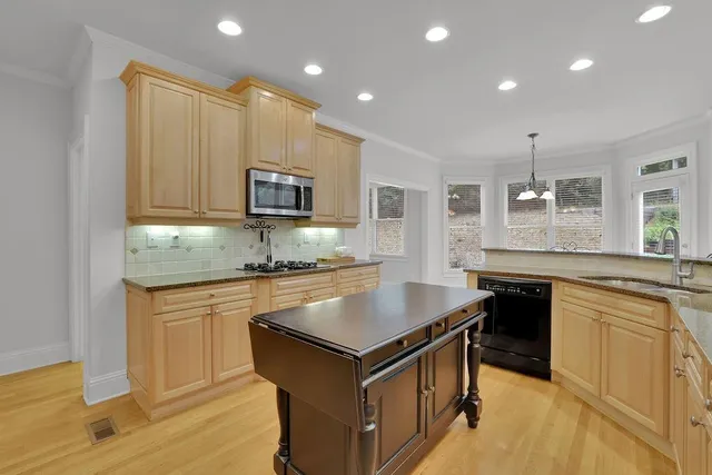 a kitchen with stainless steel appliances a stove sink microwave and cabinets