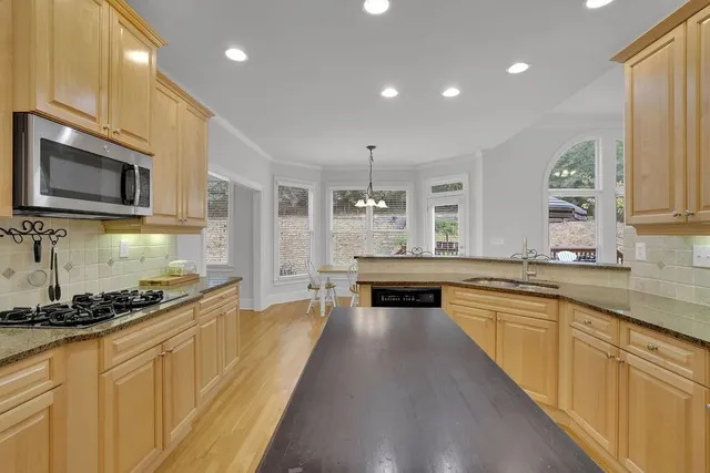 a kitchen with stainless steel appliances granite countertop a stove and a kitchen island