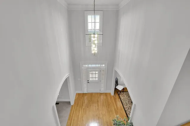 a view of a hallway with wooden floor and staircase