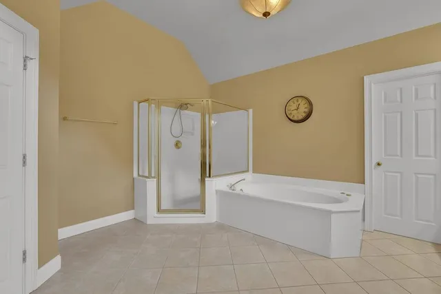 a spacious bathroom with a granite countertop sink a mirror and a bathtub