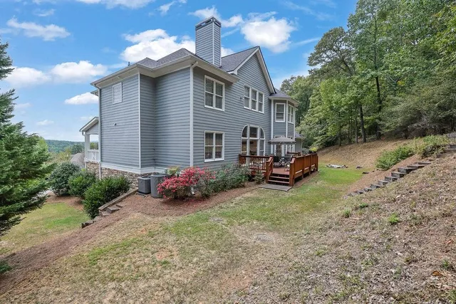 a view of a backyard with potted plants and large trees