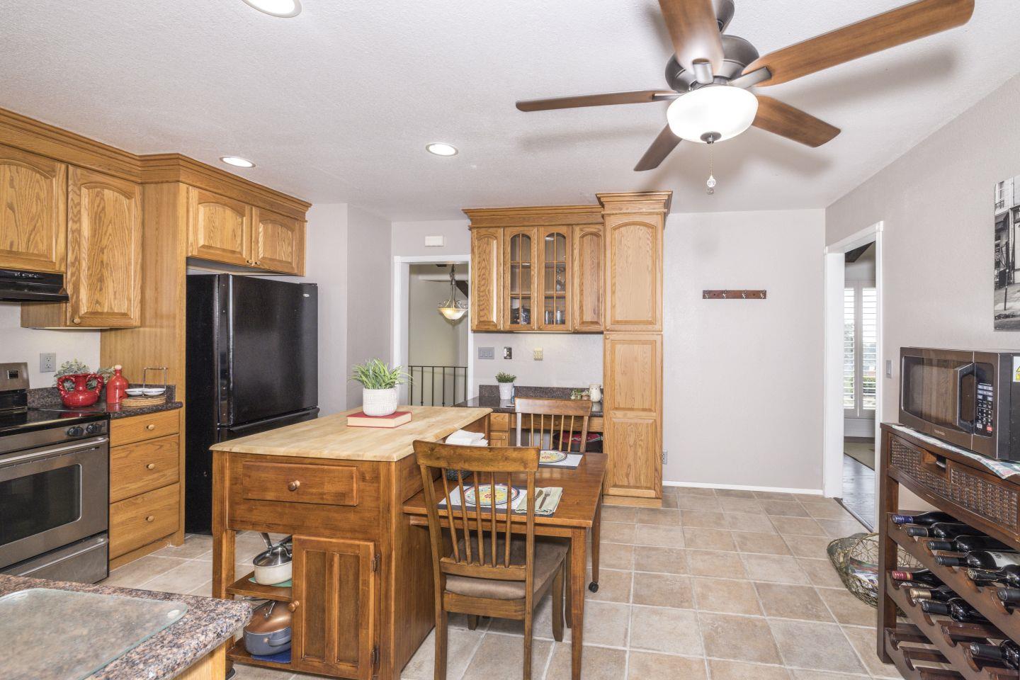 27975 Edgecliff Way Hayward, CA 94542 - Photo 14 of 58 a kitchen with a table chairs refrigerator and cabinets