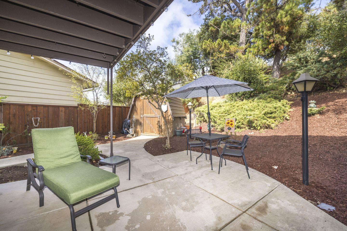 27975 Edgecliff Way Hayward, CA 94542 - Photo 43 of 58 a view of a patio with couches table and chairs under an umbrella with a barbeque
