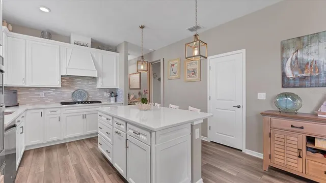 a dining room with furniture a chandelier and wooden floor