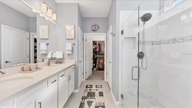 a bathroom with a double vanity sink a mirror and a shower
