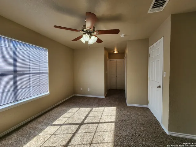 a view of an empty room and window chandelier fan