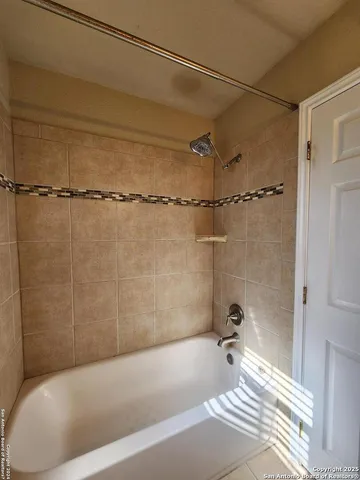 a bath tub sitting next to a white sink and a shower