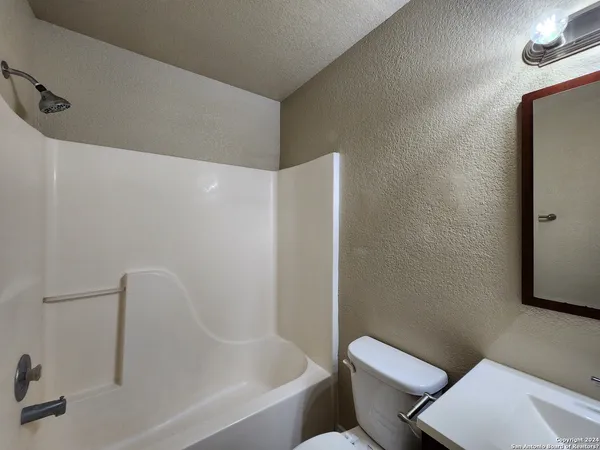 a white bath tub sitting next to a toilet