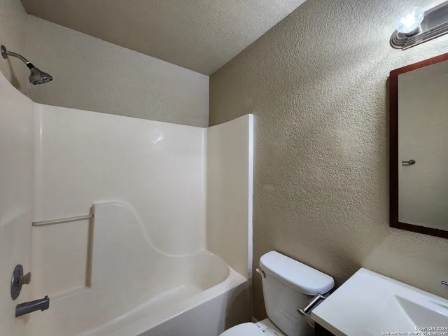 a white bath tub sitting next to a toilet