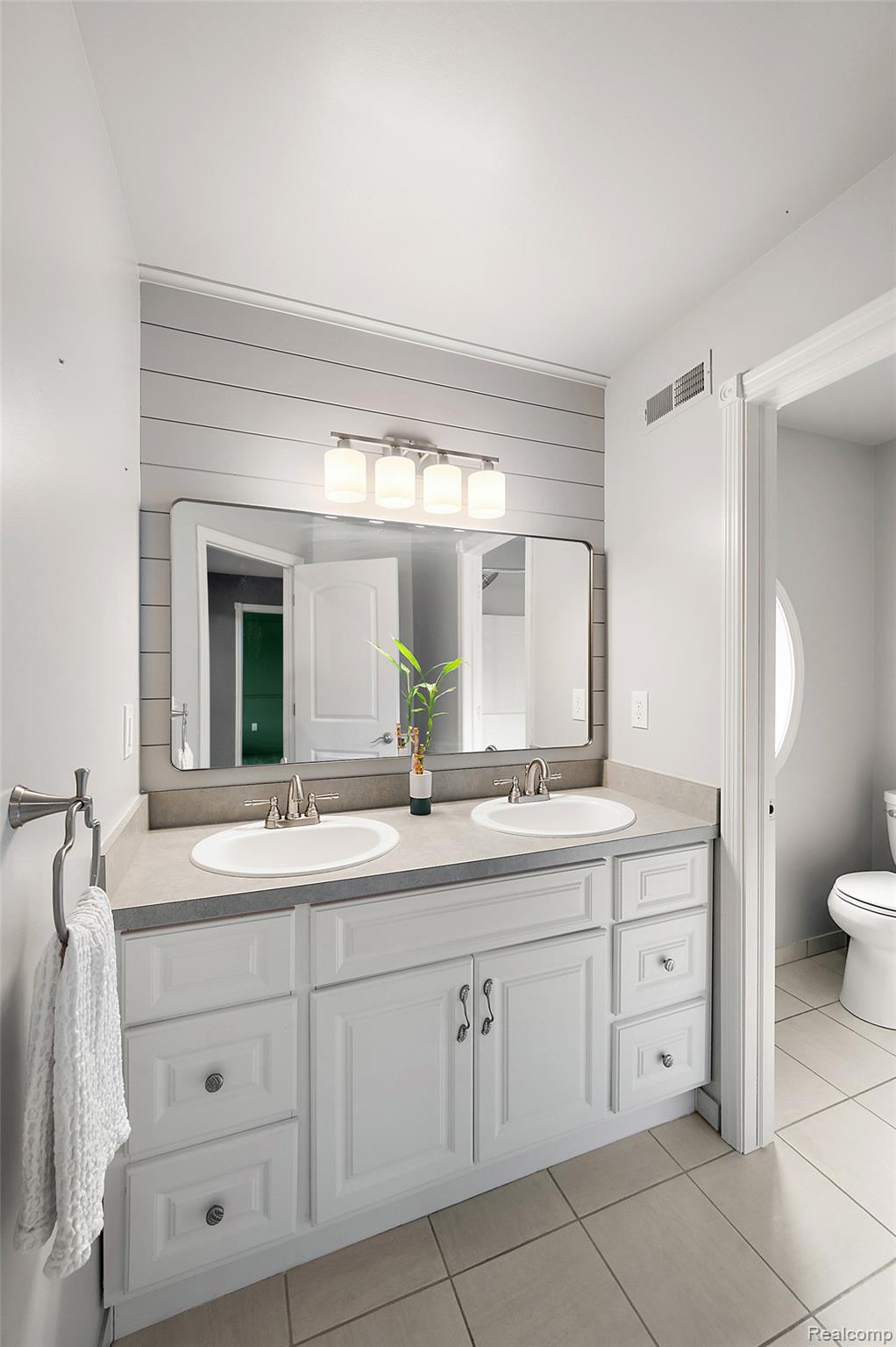 5035 Hidden Ridge Road Metamora, MI 48455 - Photo 42 of 65 Double vanity with white cabinetry, dual undermount sinks, and a light-toned countertop