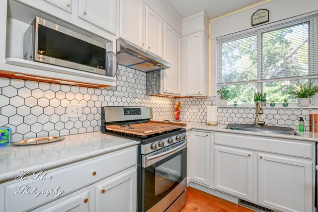 a kitchen with stainless steel appliances a stove microwave and refrigerator