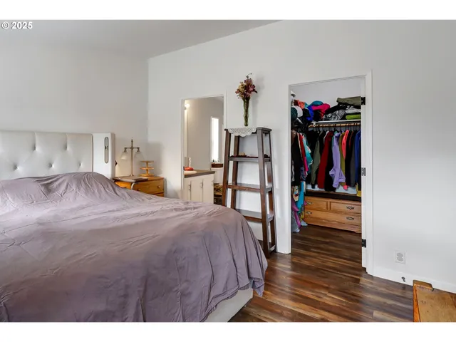 a bed room with a bed and a view of kitchen