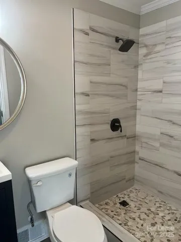 a bathroom with a toilet and a shower