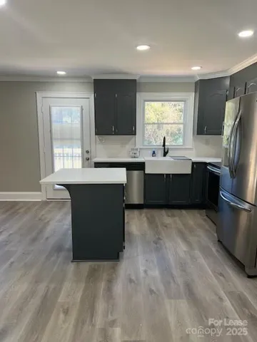 a kitchen with kitchen island sink refrigerator and window